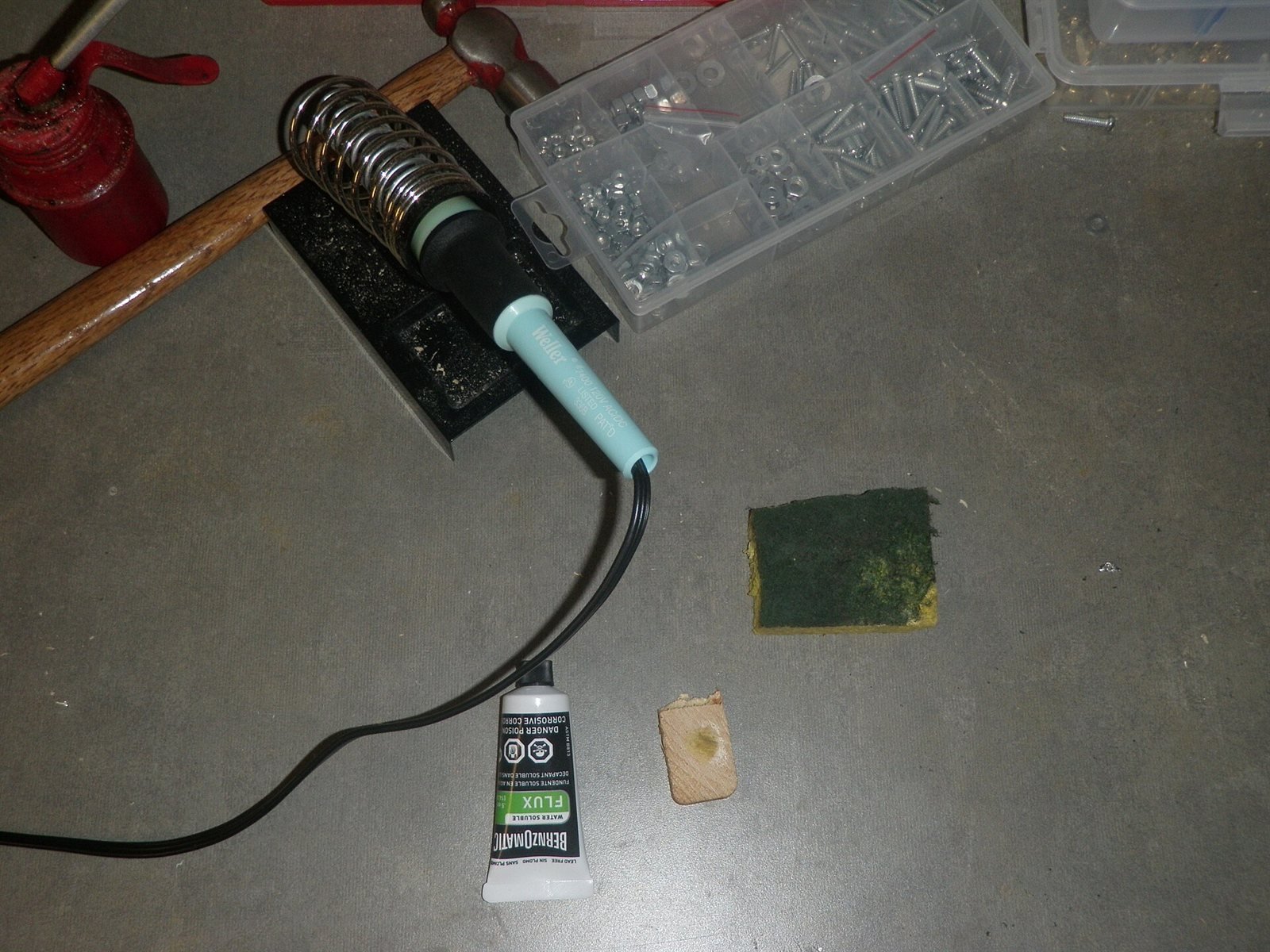 Soldering iron tip with flux and cleaning tools on a work surface