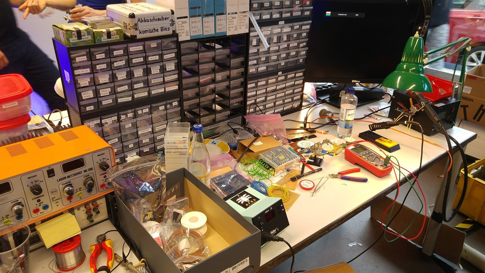 Improvised computer repair bench with soldering irons and spare parts